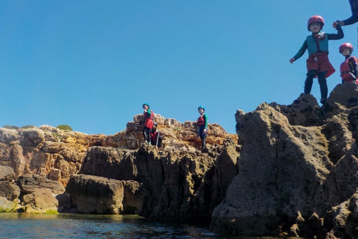 a man flying through the air on a rock