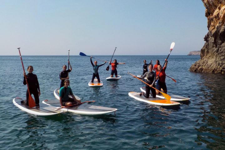 a group of people riding on the back of a boat in the water