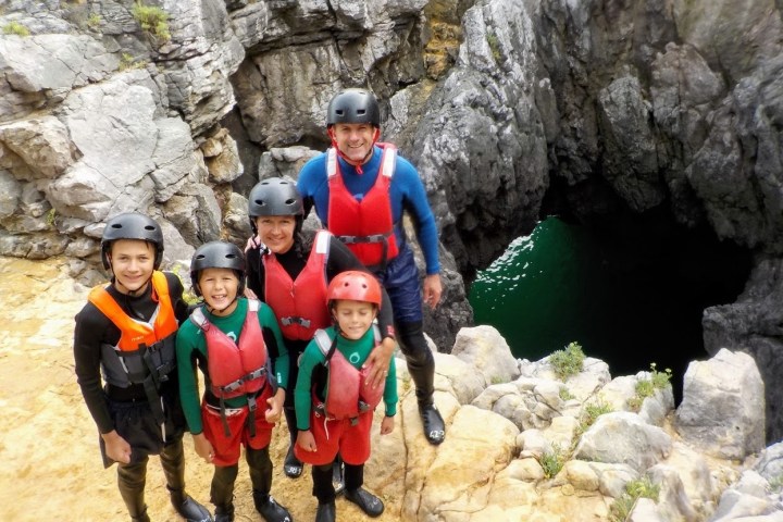 a group of people standing in front of a rock
