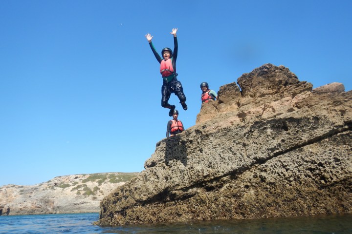 a man flying through the air on a rock