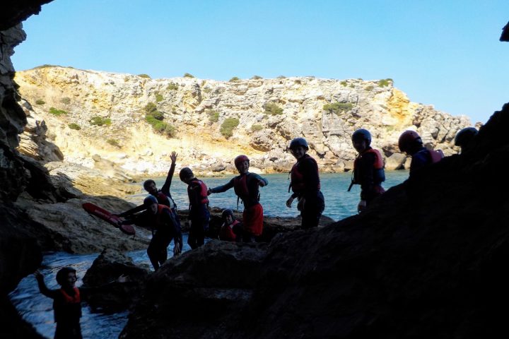 a group of people standing on a rocky hill