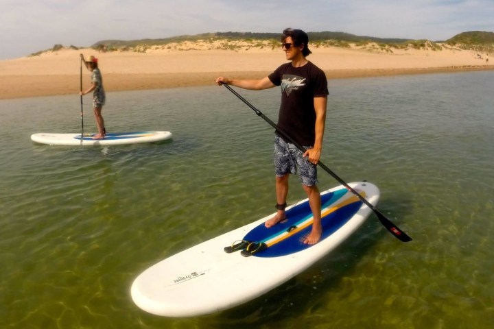 a man standing next to a body of water