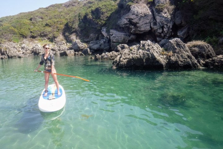a person standing next to a body of water