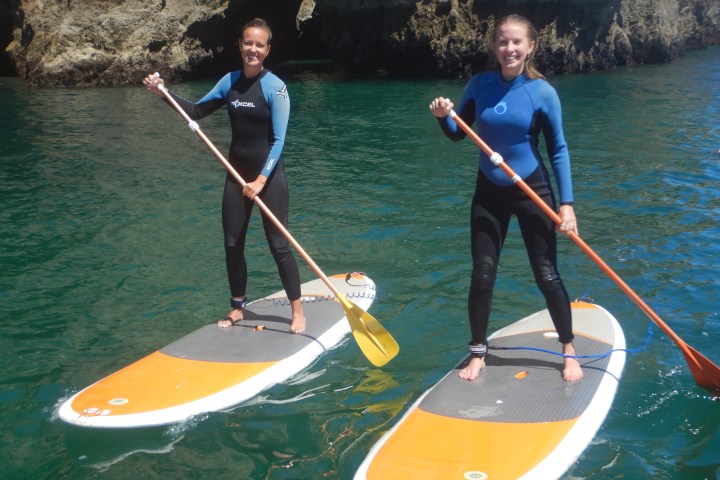 a group of people standing next to a body of water