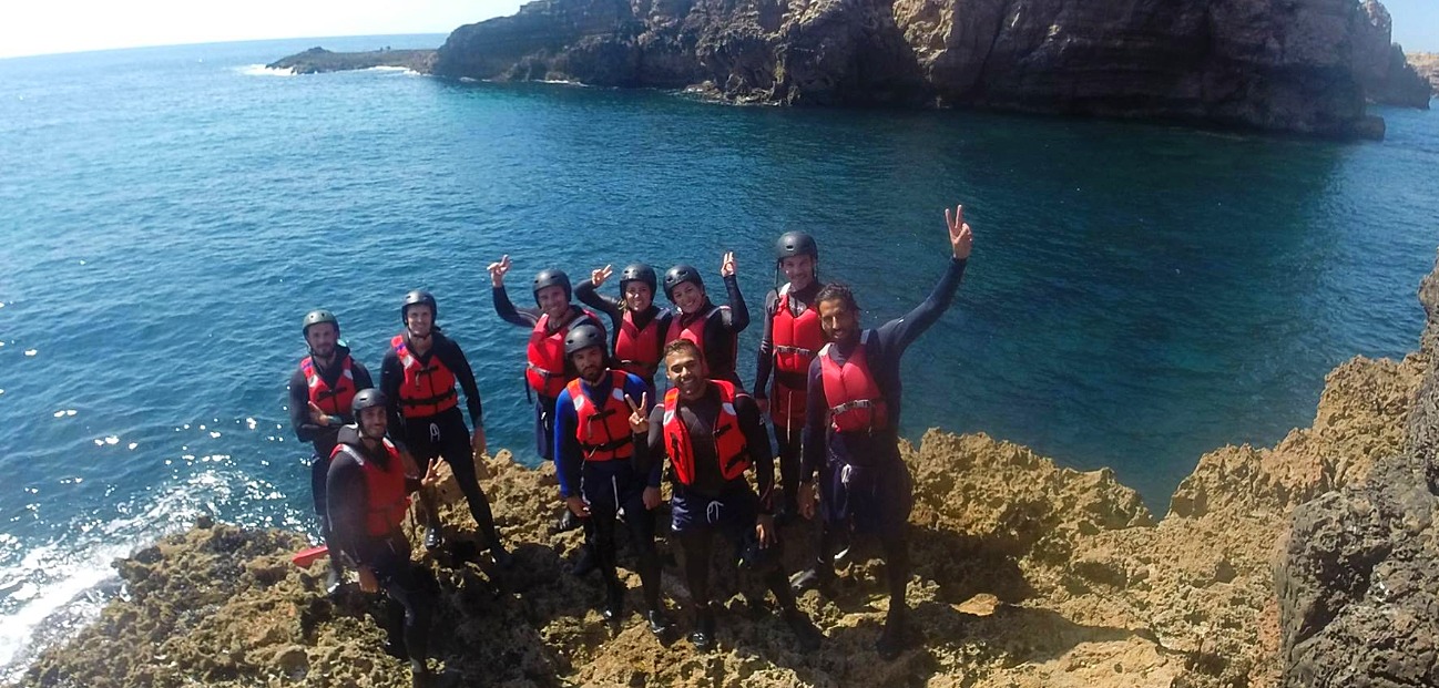 SUP & Coasteering instructors job a group of people standing next to a body of water
