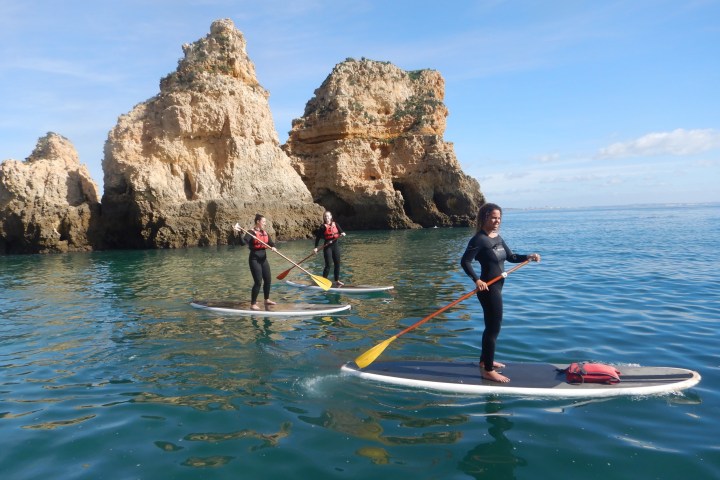 a group of people riding on the back of a boat in the water